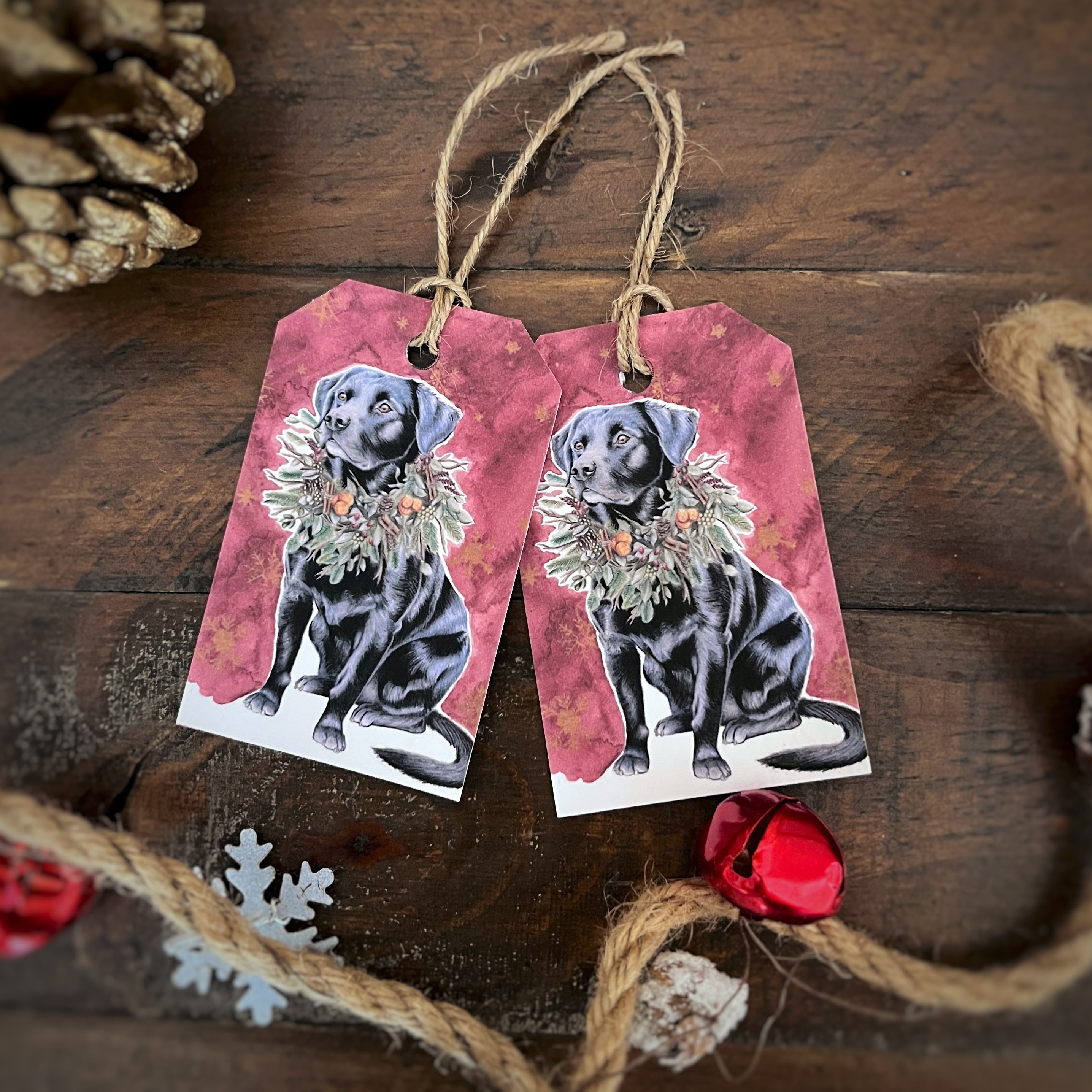 Handmade illustration of black Labrador sitting with Christmas wreath around its neck and red painted background 